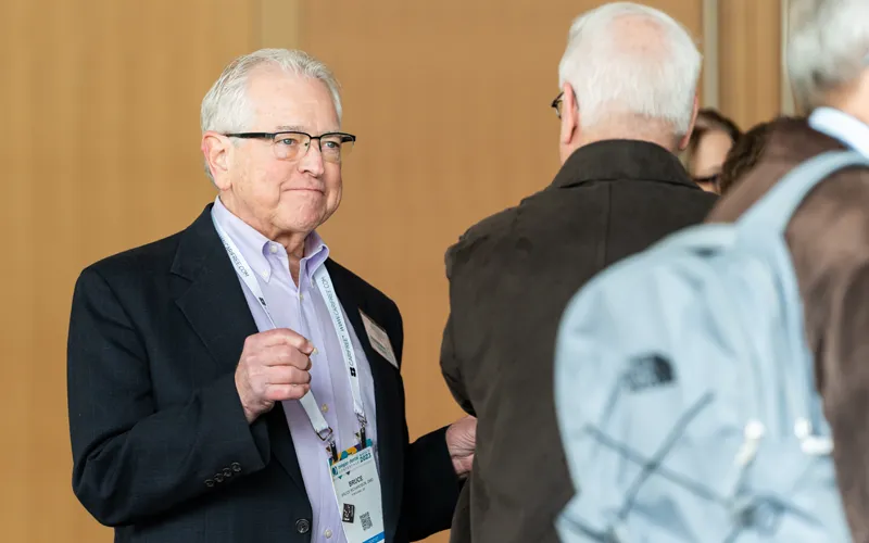 D.M.D. alumnus speaks with another alumnus.